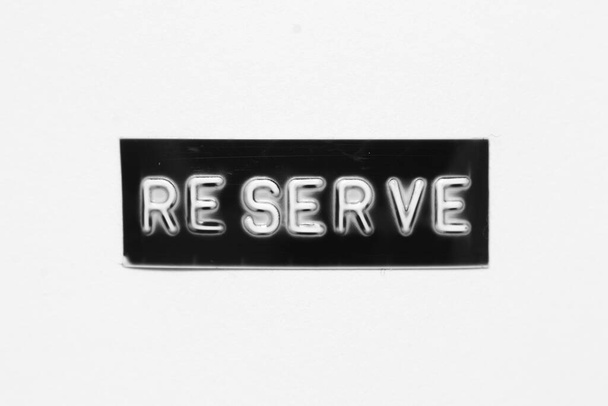 Black color banner that have embossed letter with word reserve on white paper background - Photo, Image