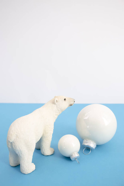 Creative concept made  with white baubles and polar bear on a cyan background. Minimal New Year arrangement. - Photo, image