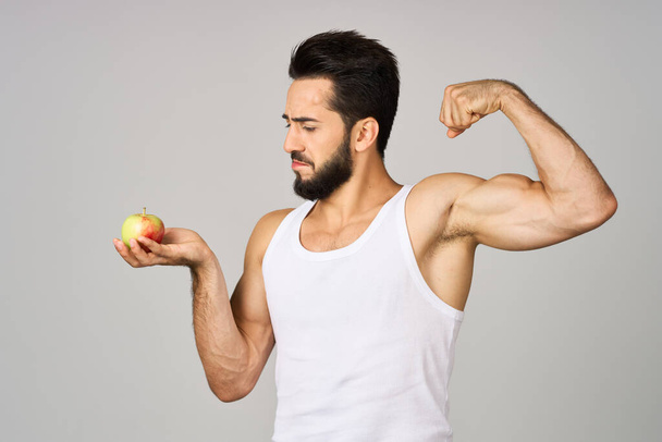 a man in a white t-shirt fresh fruit apples vitamins isolated background - Φωτογραφία, εικόνα