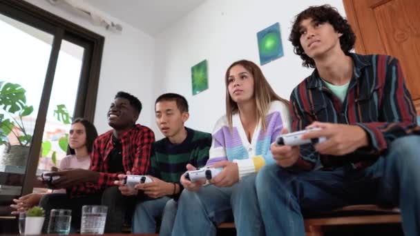 Νέοι πολυφυλετικοί έφηβοι που παίζουν online κονσόλα βιντεοπαιχνιδιών στο σπίτι - Νέοι άνθρωποι εθισμένοι στην ψυχαγωγία τυχερών παιχνιδιών νέας τεχνολογίας - Πλάνα, βίντεο