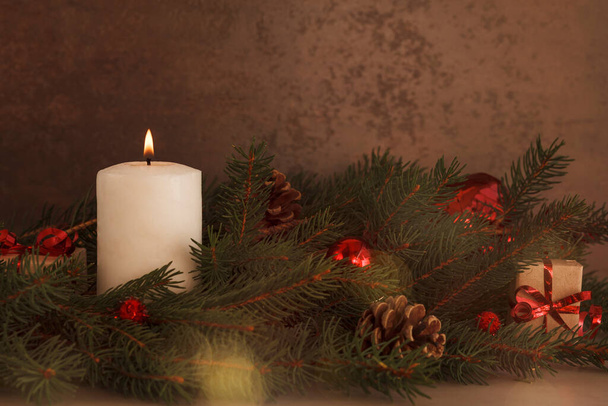 Christmas composition with sprigs of fir trees, cones, red balls and candle - Φωτογραφία, εικόνα
