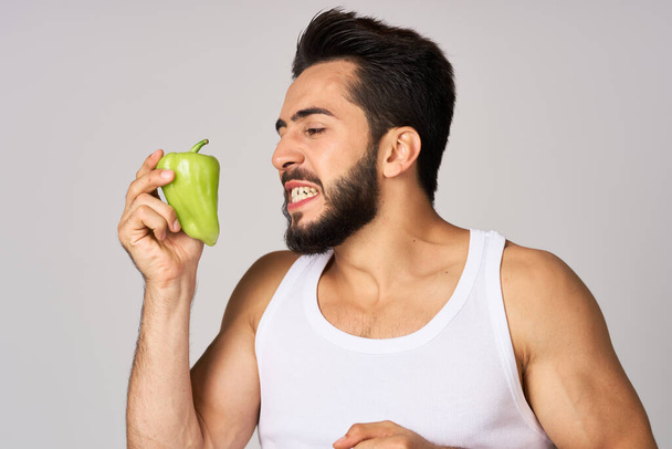 bearded man green pepper snack healthy food emotions - Foto, afbeelding