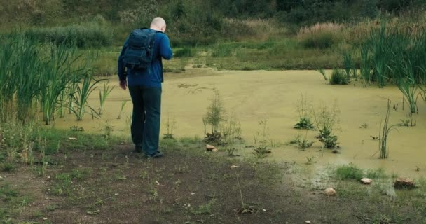 Caminhante com uma mochila se aproximou do pântano. Um homem não pode andar por um pântano - Filmagem, Vídeo