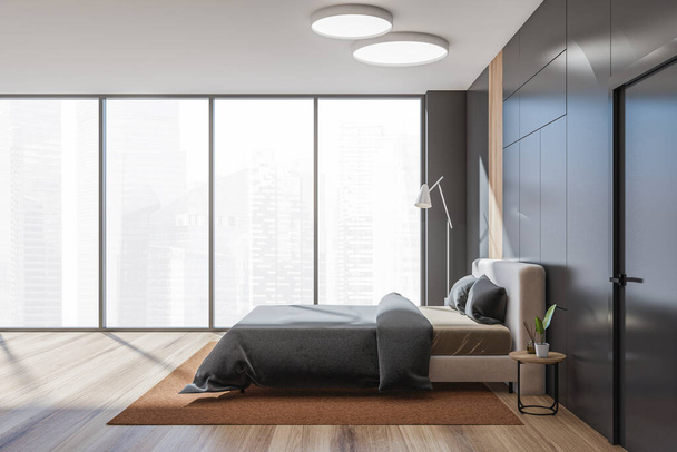 Black bedroom interior, bed linens and pillows, side view, carpet and parquet floor, panoramic window with city view on skyscrapers. Nightstand with decoration, 3D rendering - Photo, image