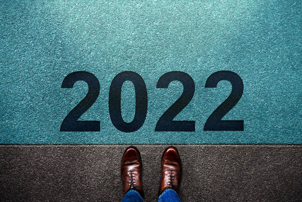 Koncepcja roku 2022. Widok na Biznesmena stojącego na linii startu. Przygotuj się na kolejne kroki w nowym roku. Metafora zdjęcie - Zdjęcie, obraz