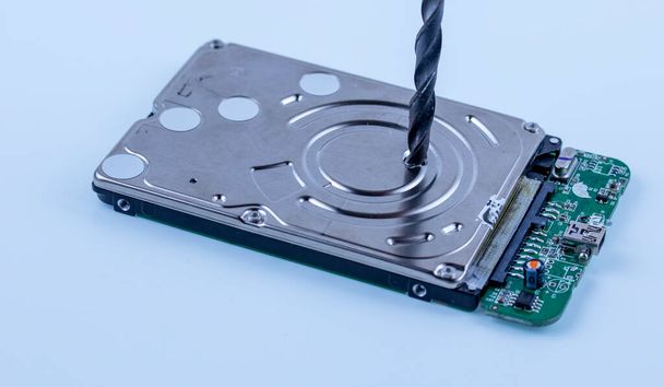 жорсткий диск з комп'ютера просвердлюється великим дрилем, макро фото
 - Фото, зображення