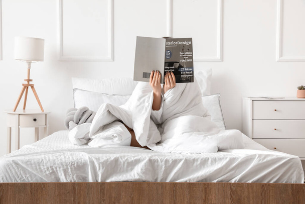 Πρωί της νεαρής γυναίκας ανάγνωση περιοδικό στο κρεβάτι - Φωτογραφία, εικόνα