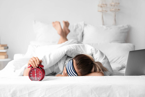 Утро молодой женщины с будильником спит в постели - Фото, изображение