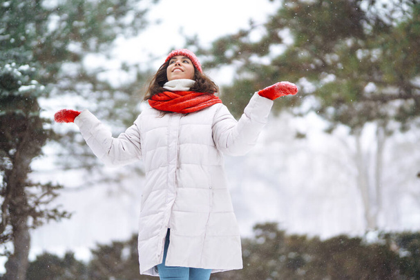 Young woman in winter style clothes walking in the snowy winter day outdoor. Nature, holidays, rest, travel concept. - 写真・画像