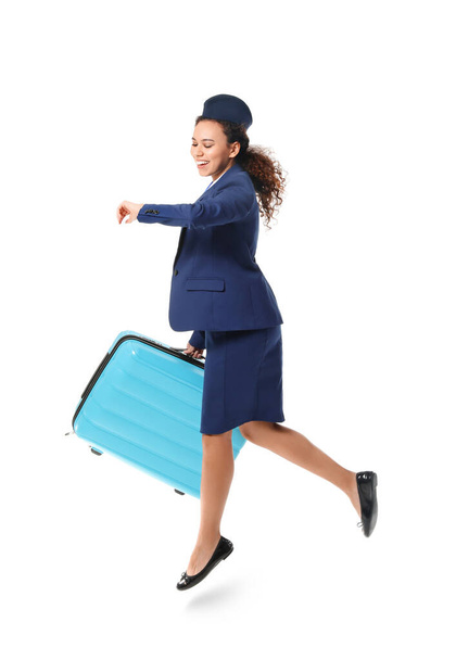 Saltando azafata afroamericana con maleta sobre fondo blanco - Foto, Imagen