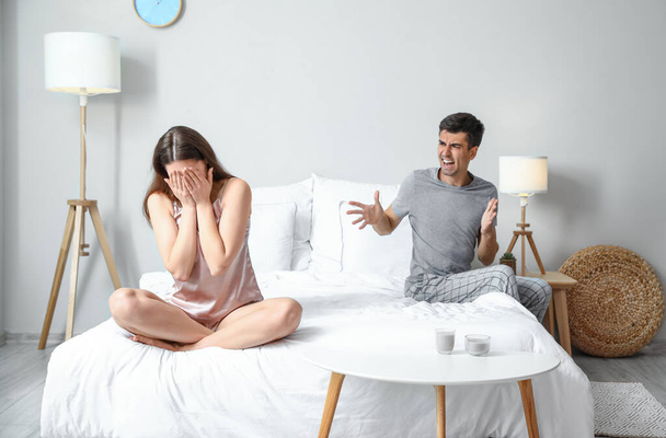 Angry young man shouting at his wife in bedroom - Photo, Image