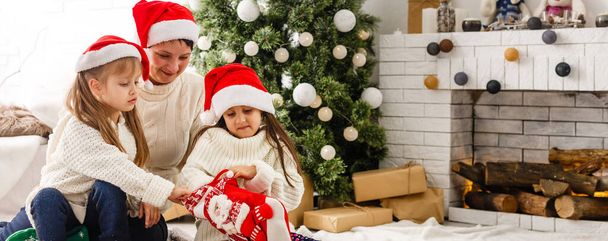 dwie małe dziewczynki Dzielenie się niespodzianką na Boże Narodzenie rano - Zdjęcie, obraz
