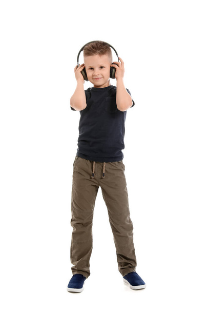 Cute little boy listening to music and dancing on white background - Foto, afbeelding