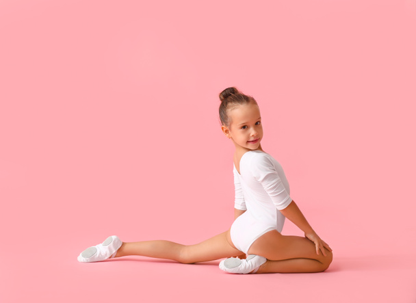 Маленька дівчинка робить гімнастику на кольоровому фоні
 - Фото, зображення