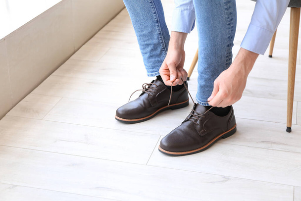 Homme attachant des lacets de chaussures à la maison, gros plan - Photo, image