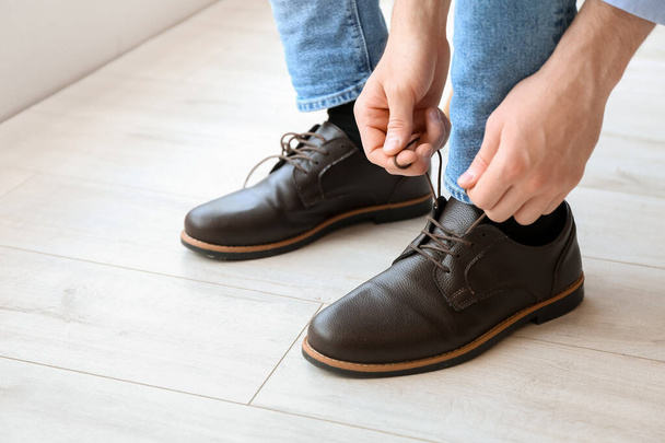 Hombre atando cordones de zapatos en casa, primer plano - Foto, Imagen