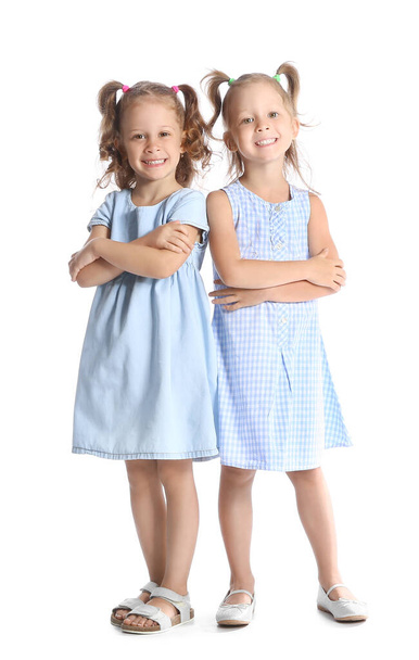 Adorable little sisters in blue dresses on white background - Photo, Image