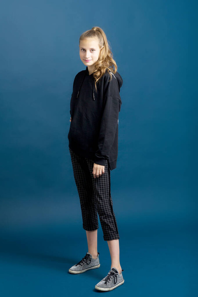 Teenage girl in black hoodie and plaid trousers - Φωτογραφία, εικόνα