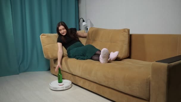 Staubsaugerroboter liefert Alkohol an Frau auf Sofa - Filmmaterial, Video