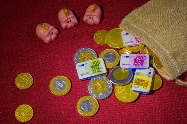 Čokoládové mince rozházené kolem, pytel a marcipánové prasečí břehy. Koncept pro drahé dovolené, jako jsou Vánoce a Sinterklaas - Fotografie, Obrázek