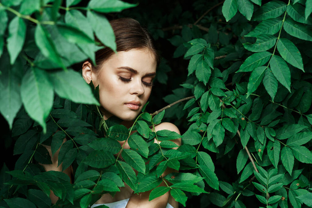 Gülümseyen kadın cilt bakımı çıplak omuzlar yeşil yapraklar doğaya yakın çekim - Fotoğraf, Görsel