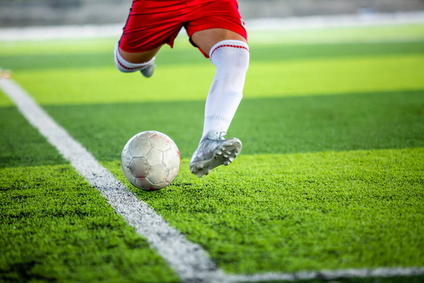 Вибірковий фокус на футбольному м'ячі з розмитим футболістом біжить, щоб стріляти в нього. Стріляти фоном футболу
. - Фото, зображення