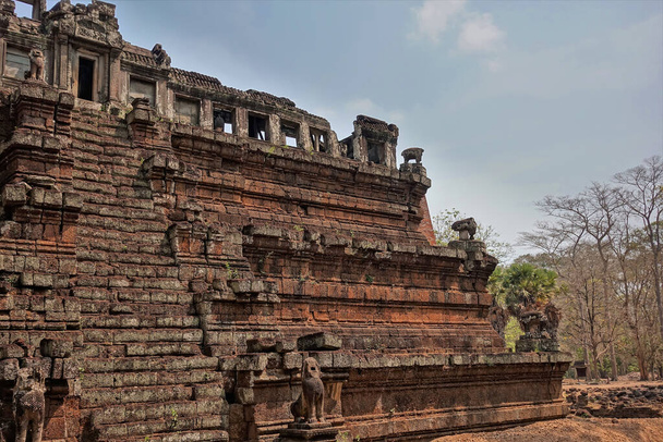 Templo de Phimeanakas no famoso Angkor. Um edifício pisado na forma de uma pirâmide de pedras vermelhas. Uma escada leva lá para cima. As aberturas de janela, uma entrada, as estátuas de animais mitológicos são visíveis. - Foto, Imagem