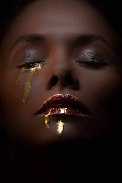 Gold on the skin, face art and creative makeup, gold as tears and blood - Photo, Image