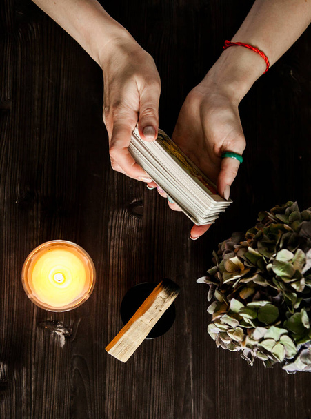  tarot cards in hands on a dark background in the light of a candle - Foto, Imagem