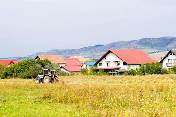 venkovské letní krajina s traktorem a chaty - Fotografie, Obrázek