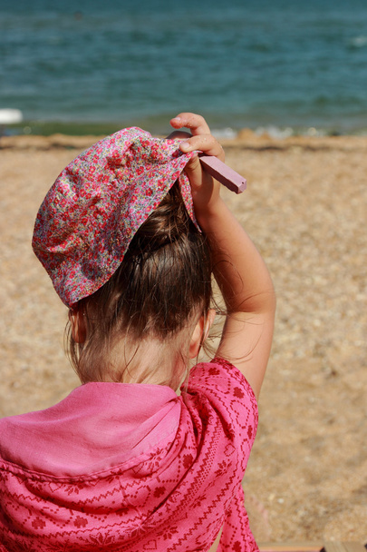 kleines Mädchen sitzt am Strand - Foto, Bild