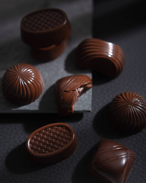 Sötét keserű csokis cukorka egy dobozban. Az édes desszert az édesség. Luxus édességek választéka - Fotó, kép