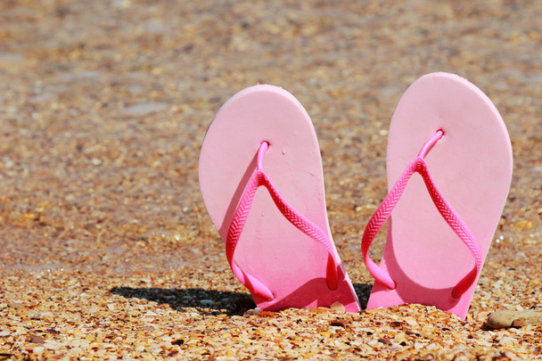 πολύχρωμες σαγιονάρες στην άμμο στην παραλία σε ηλιόλουστες ημέρες του καλοκαιριού - Φωτογραφία, εικόνα