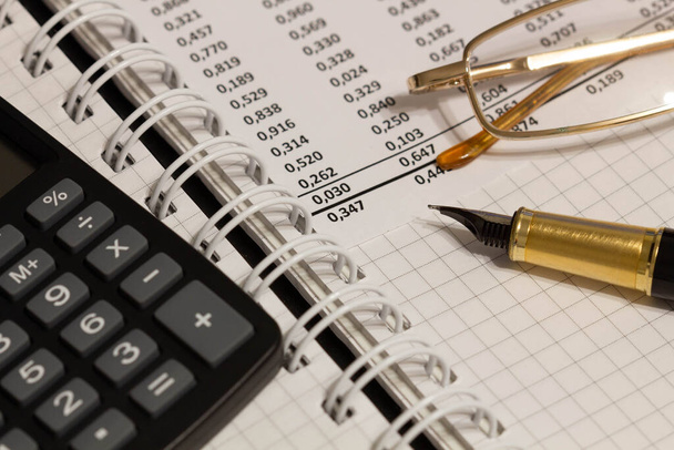 Οικονομική έκθεση, στυλό, γυαλιά και χαρτί με αριθμούς στο τραπέζι του γραφείου. Ένα φύλλο χαρτιού γεμάτο με επαγγελματικά δεδομένα. Αριθμός λογαριασμού στο δελτίο δεδομένων. Επαγγελματικά έγγραφα. Κοντινό πλάνο - Φωτογραφία, εικόνα