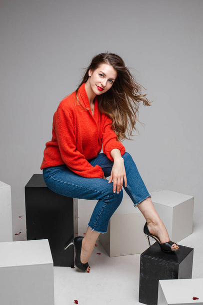 Sorridente bella donna in maglione rosso in posa in studio - Foto, immagini