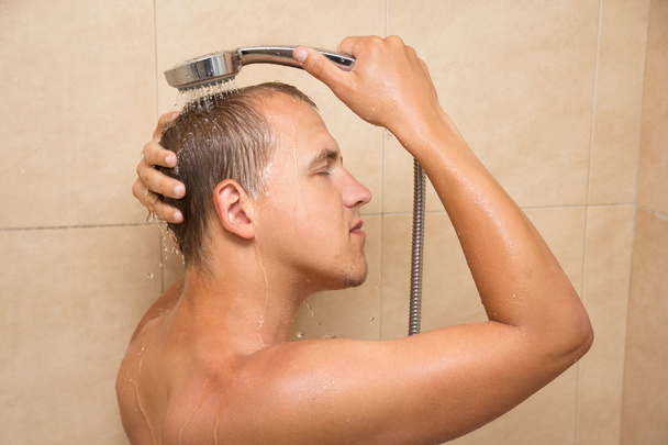 Arkadan Görünüm gencin banyoda saç yıkama - Fotoğraf, Görsel