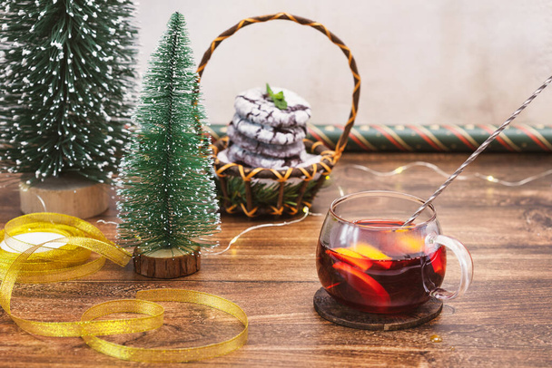 Winter holiday food. Christmas, New Year composition with cup of non alcoholic mulled wine with citrus fruit slices and home made chocolate cookies with holiday decor - Foto, Imagen
