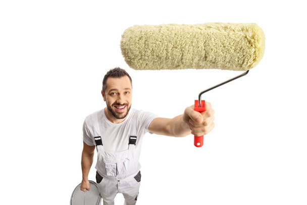 House painter holding a paint roller in front of camera isolated on white background - Фото, зображення