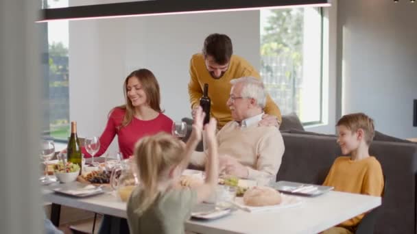 Gelukkig gezin met een diner met rode wijn thuis - Video