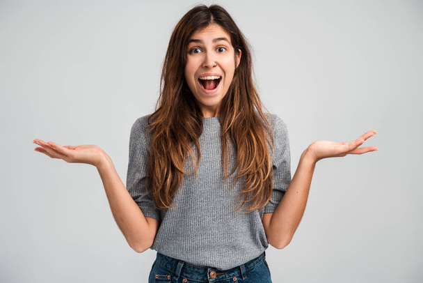 Portrait of happy rejoicing young woman with long hair in hat screaming and celebrating her victory with amazed excited face. Indoor studio shot isolated on white background - Photo, Image