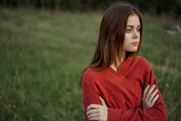 woman in a red sweater outdoors in a field walk - Fotoğraf, Görsel