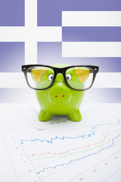 cofrinho sobre mercado de ações gráfico com bandeira grega no fundo - parte da série - Foto, Imagem