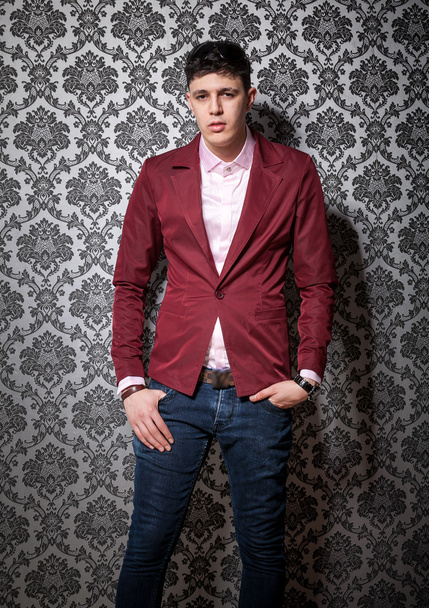sexy man in red jacket leaning against fancy wall - Photo, Image