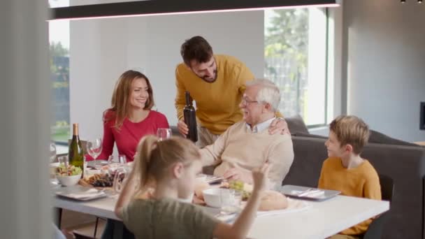 Heureuse famille qui dîne avec du vin rouge à la maison - Séquence, vidéo