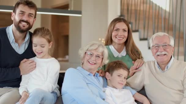 自宅のソファに座っている複数の世代の家族 - 映像、動画