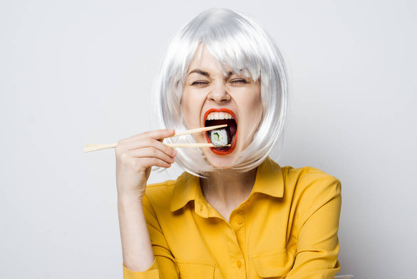 pretty woman in white wig and sushi with Japanese chopsticks - Photo, Image