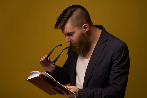 bearded man in a black jacket with a book in his hands education - Foto, Imagem