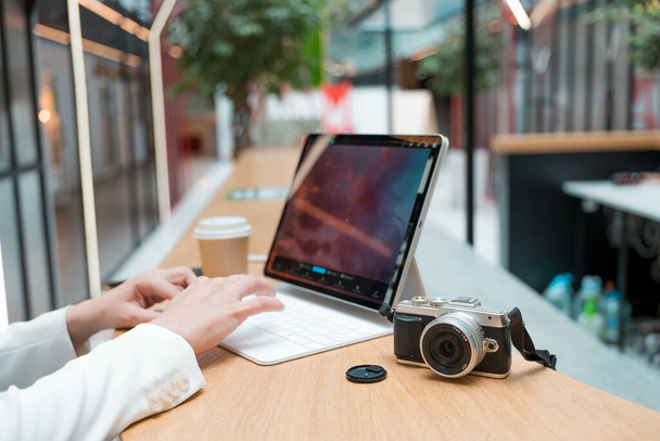 A freelance photographer works remotely, a thin mobile computer with a photo on the screen - Foto, immagini