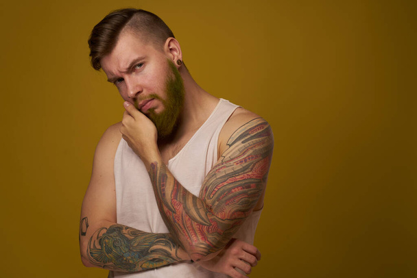 bearded man in white t-shirt with tattoos on his arms posing serious look - Foto, immagini