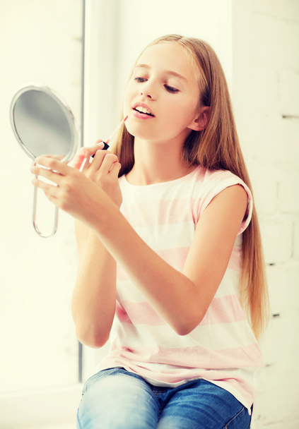 teenage girl with lip gloss and mirror - Foto, afbeelding